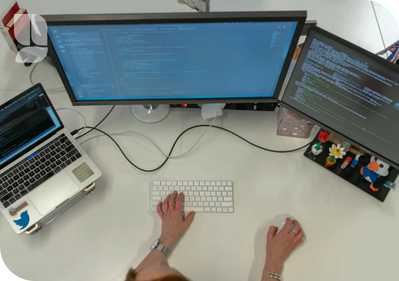 Persona trabajando con una computadora y dos monitores
